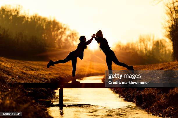 dansende moeder en dochter op een kleine brug - balancing act stockfoto's en -beelden