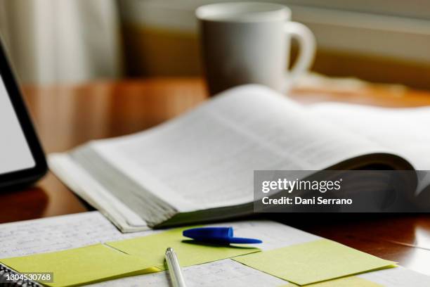 a book along a notebook a marker and a coffee mug - ensino doméstico imagens e fotografias de stock