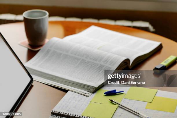 a book along a notebook a marker and a coffee mug - book on table foto e immagini stock