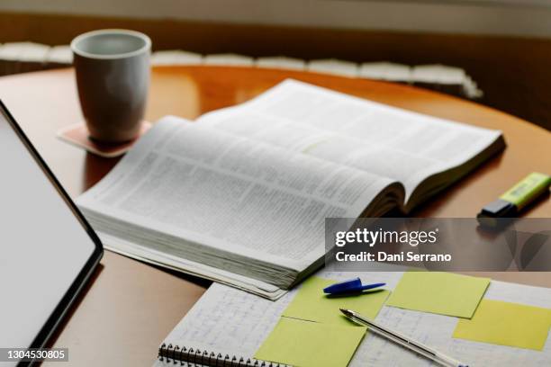 a book along a notebook a marker and a coffee mug - estudos imagens e fotografias de stock