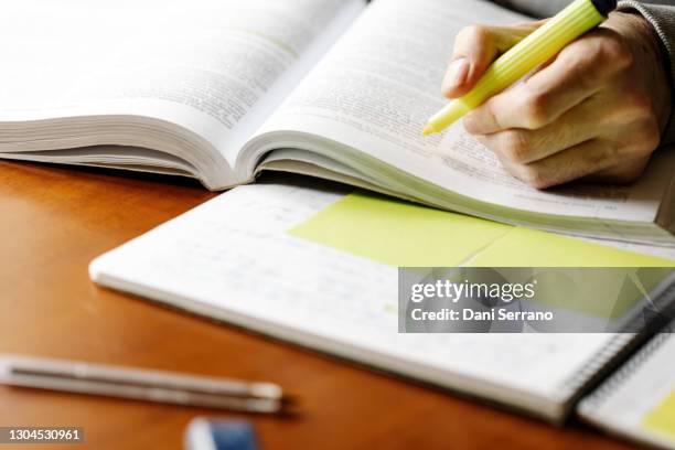 man with marker pen reading book - textbook stock pictures, royalty-free photos & images