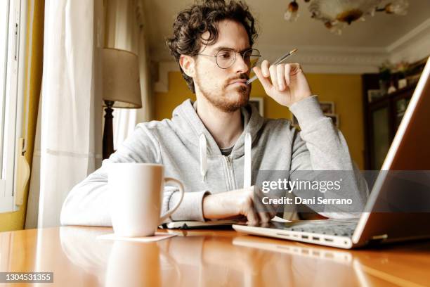 thoughtful freelancer working with laptop at home - search the internet stock pictures, royalty-free photos & images