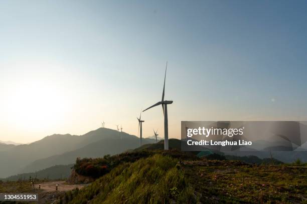 towering wind turbines on a mountain at dusk - wind power city stock pictures, royalty-free photos & images