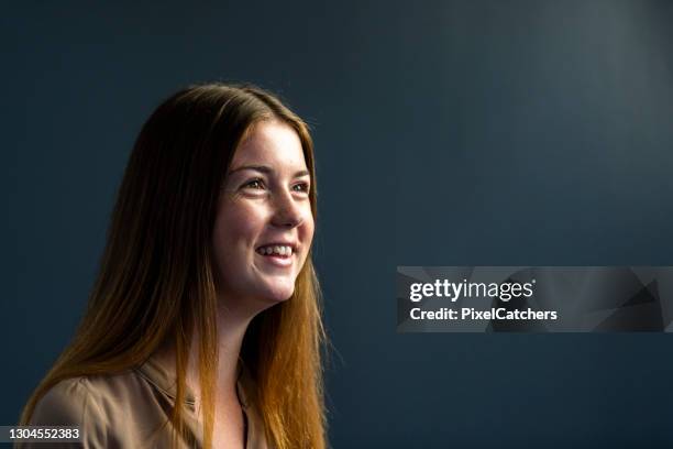 portrait happy young woman on dark grey background - woman on gray background stock pictures, royalty-free photos & images