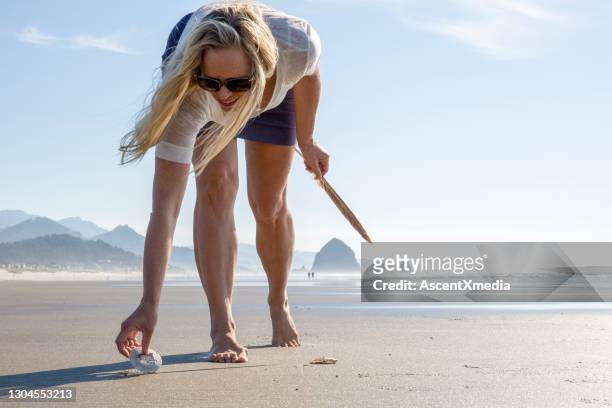 la femme recueille des coquillages sur la plage vide - côte de l'oregon photos et images de collection