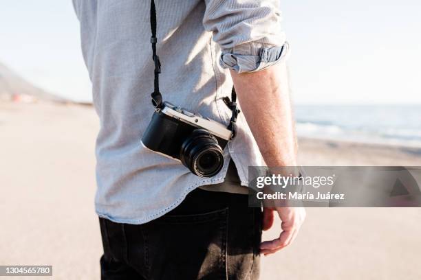 man holding a mirrorless digital camera - slr camera stock pictures, royalty-free photos & images