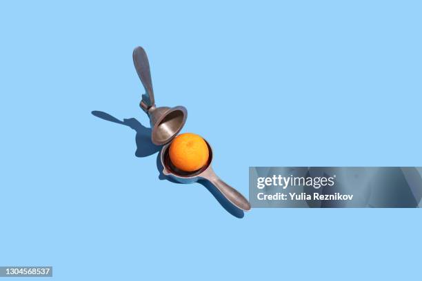 lemon squeezer and blood orange on the blue background - squeezing imagens e fotografias de stock