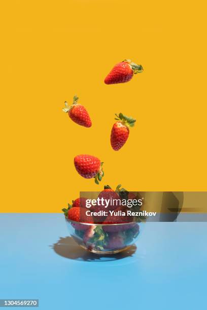 strawberries flying in the bowl on the blue-yellow background - strawberry 個照片及圖片檔