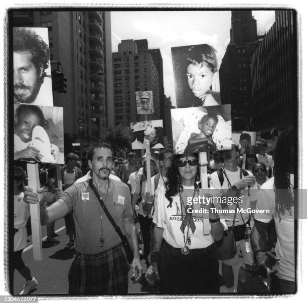 Marchers in New York's Gay Pride Parade carry signs with pictures of people who have died from AIDS on June 26, 1994 in New York City, New York.