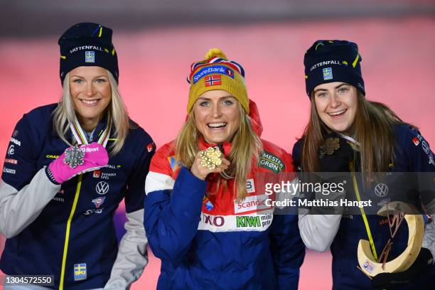 Silver medalist Frida Karlsson of Sweden, gold medalist Therese Johaug of Norway and bronze medalist Ebba Andersson of Sweden celebrate during the...