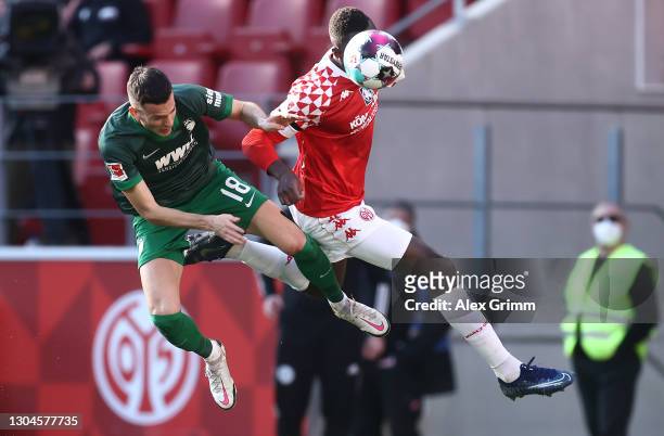 Laszlo Benes of Augsburg is challenged by Moussa Niakhate of Mainz during the Bundesliga match between 1. FSV Mainz 05 and FC Augsburg at Opel Arena...