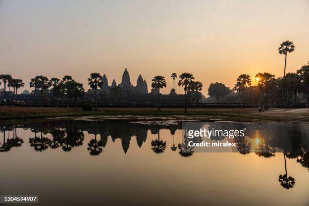 sunrise at angkor wat temple with towers reflected in water - siem reap stock pictures, royalty-free photos & images
