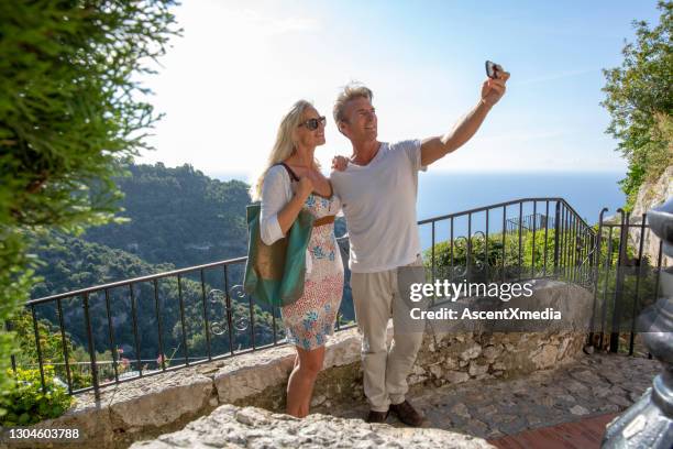 het paar neemt selfie van balkon over het overzees en het bos - early retirement stockfoto's en -beelden