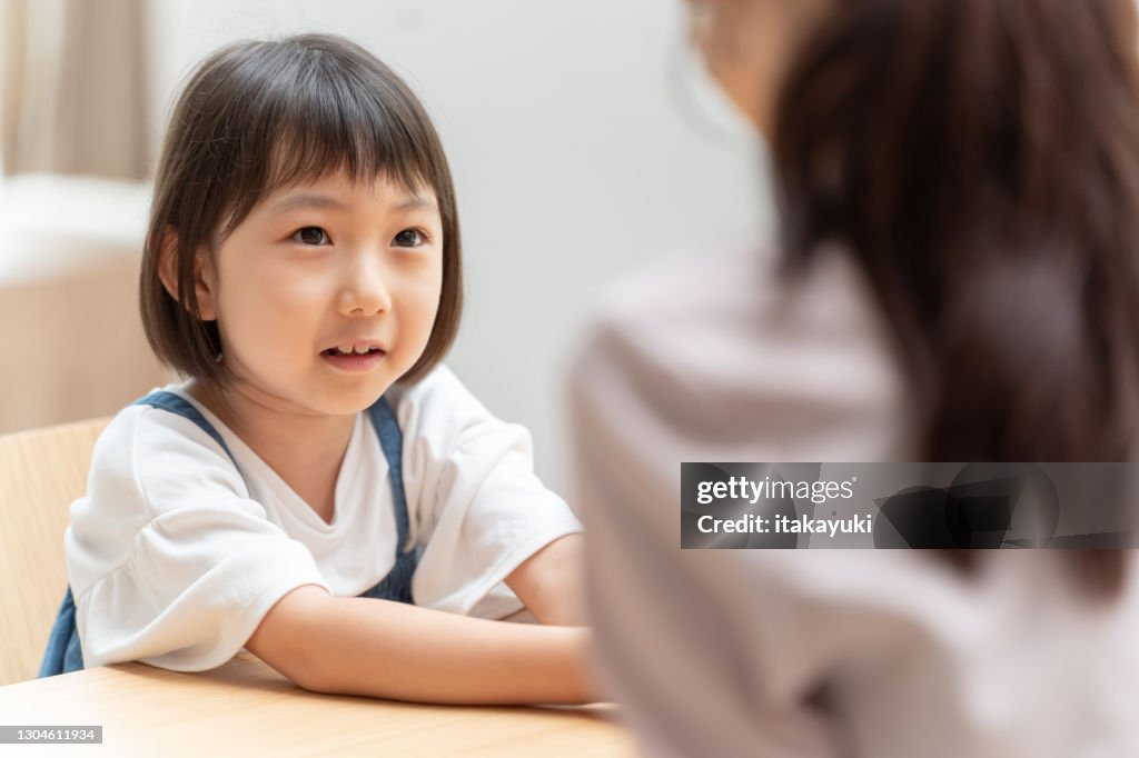 Young japanese family talking in living room