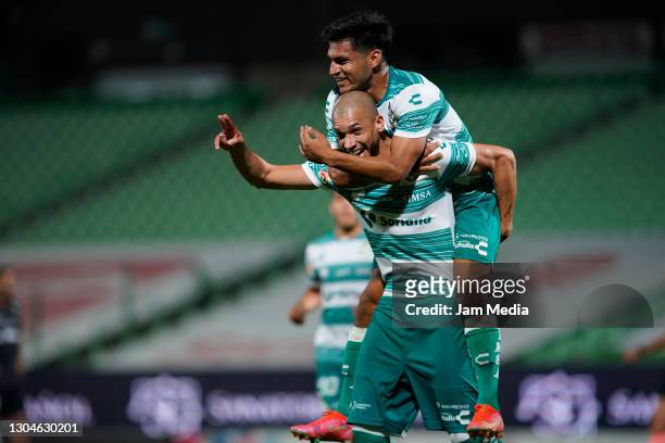 Matheus Doria of Santos celebrates with teammate Eduardo Aguirre after scoring the third goal of his team during the 8th round match between Santos...