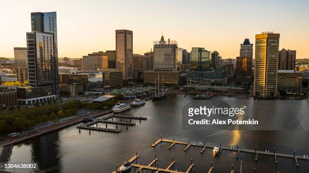 the aerial view of the inner harbor on patapsco river in baltimore, maryland, usa, at sunset. - baltimore maryland imagens e fotografias de stock