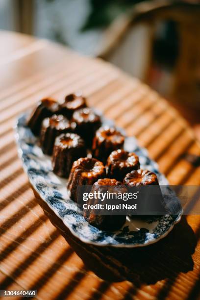 homemade canele on wooden table - canelé stock-fotos und bilder