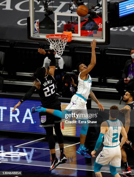 Malik Monk of the Charlotte Hornets makes a basket with one second left to tie their game and is fouled by Richaun Holmes of the Sacramento Kings at...