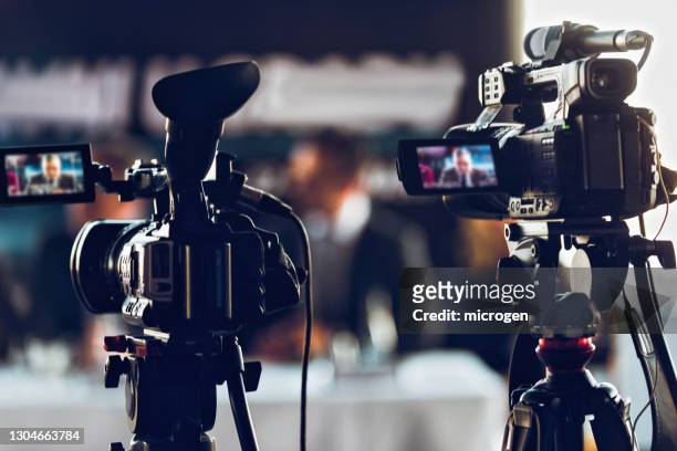 professional digital camera recording presentation a a blurred speaker wearing suit - the media stock pictures, royalty-free photos & images