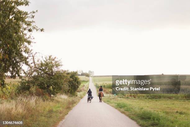 father with daughter traveling on horse and bicycle in rural scene - behind the green horse stock pictures, royalty-free photos & images