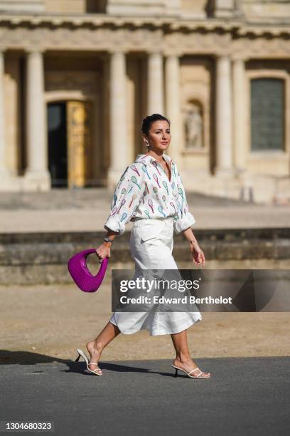 Alexandra Pereira wears earrings from APM Monaco, a white shirt with printed colored tennis rackets from Mira Mikati, a white skirt with pockets from...