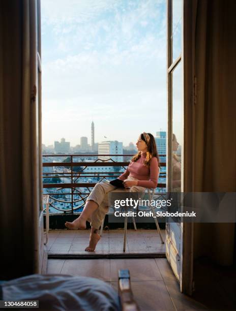 woman sitting on the balcony and looking at view - le caire imagens e fotografias de stock