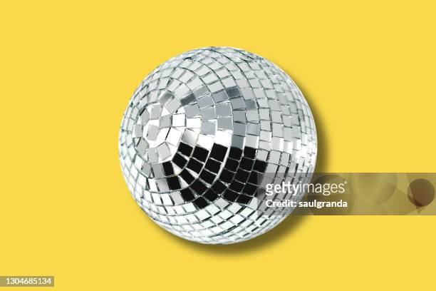 mirror ball against yellow - disco ball stock-fotos und bilder