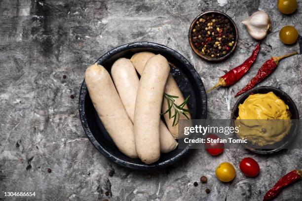 ruwe beierse worsten met kokende ingrediënten op een plaat - duitse cultuur stockfoto's en -beelden