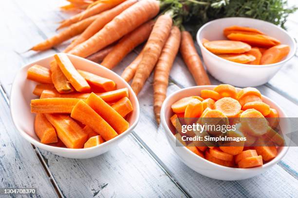 fresh carrot and carrots slices on table. - carrot foto e immagini stock