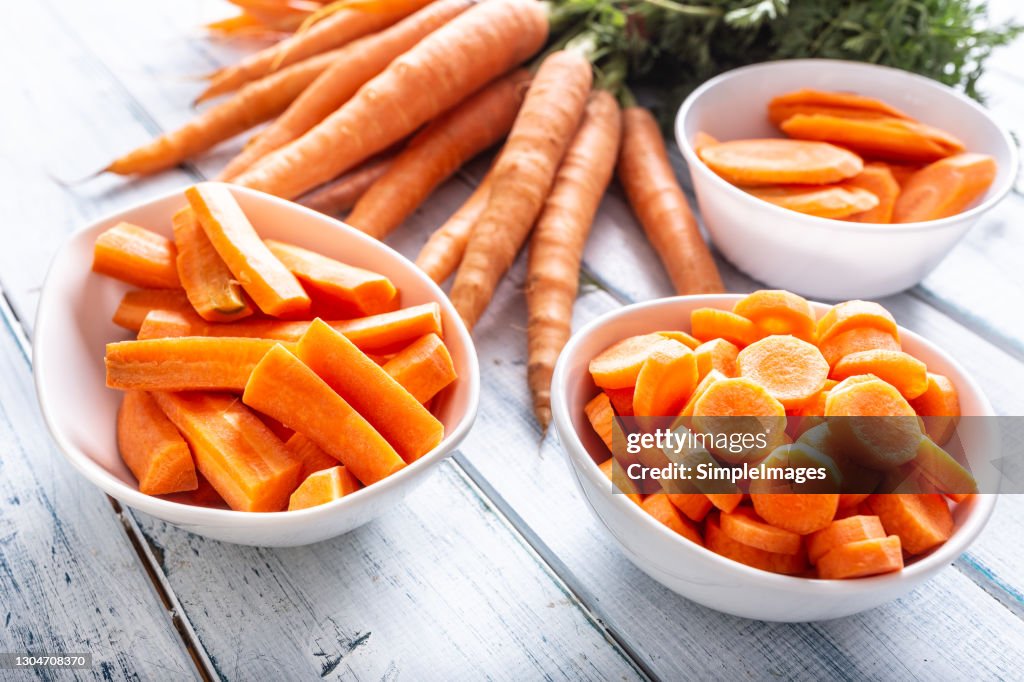 Fresh carrot and carrots slices on table.