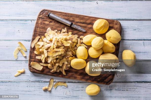 peeled potatoes on a cutting board - top of view. - batata crua imagens e fotografias de stock