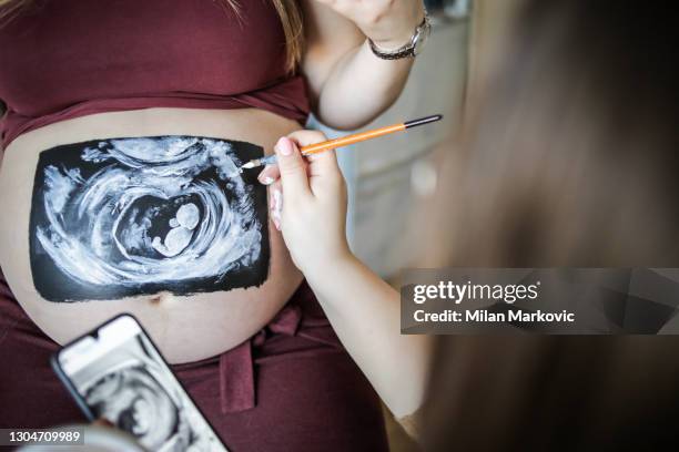 schwanger mit einem großen bauch. kunstwerk am bauch einer schwangeren frau - zeichnen auf dem bauch einer schwangeren frau - female body painting stock-fotos und bilder