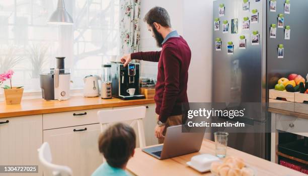 uomo che lavora a casa facendo il caffè usando una macchina per caffè espresso, ufficio casa covid-19 - caffettiera foto e immagini stock