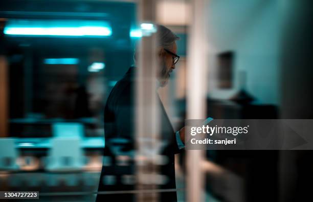 zakenman die op telefoon terwijl het lopen spreekt - smart numbers office stockfoto's en -beelden