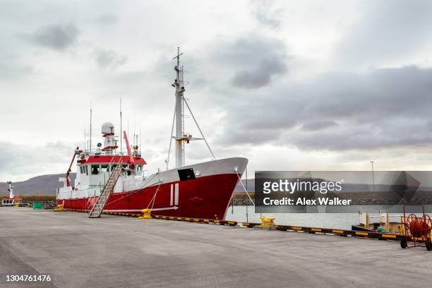 red fishing trawler boat moored at pier - iceland harbour stock-fotos und bilder