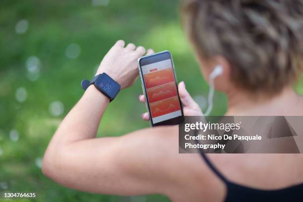 female runner checking progress - checking phone bildbanksfoton och bilder