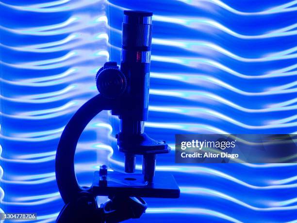 microscope in a modern and fantasy bluish environment. - light microscope stock pictures, royalty-free photos & images