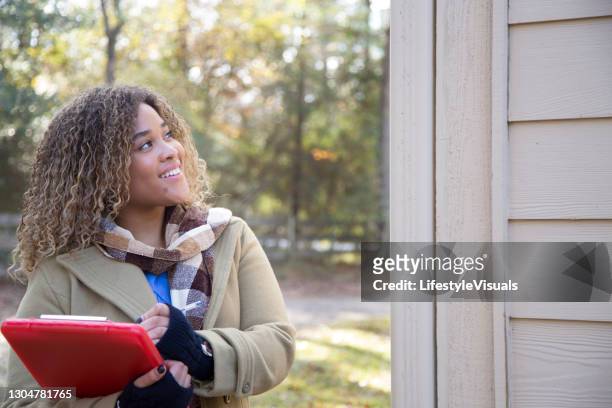 la belle femme afro-américaine complète l’évaluation d’immobiliers pour la vente à la maison. - home inspection photos et images de collection