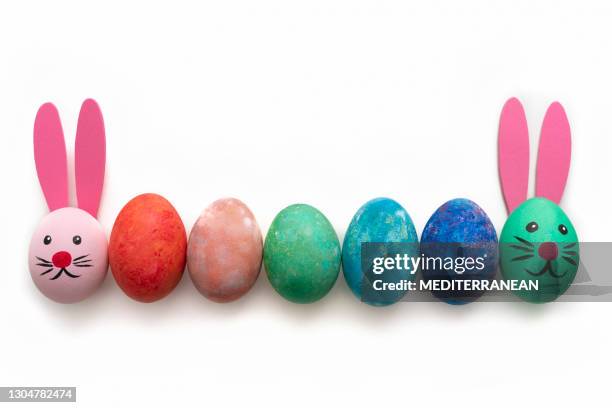 ostereier handbemalt mit hase gesicht und ohren in einer reihe auf weiß - bunny eggs stock-fotos und bilder