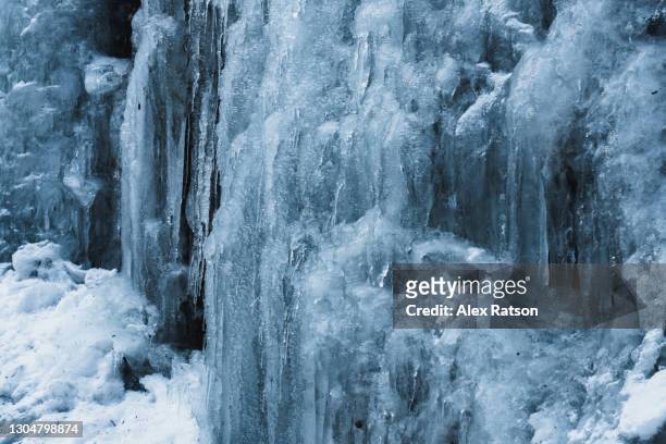 blue, frozen ice of waterfall in winter - extremlandschaft stock-fotos und bilder