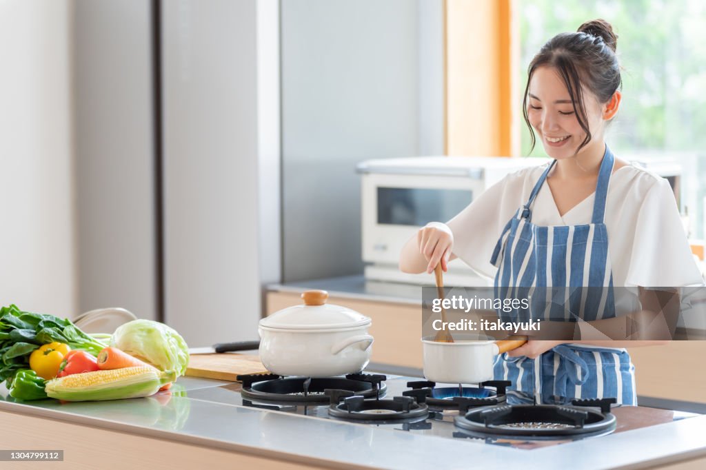 Attractive japanese woman cooking in the kitchen