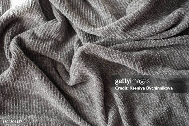 crumpled gray knitted blanket. soft and warm fabric crumpled in folds. texture for background or illustrations - wool blanket stock pictures, royalty-free photos & images