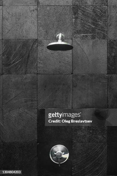 contemporary and stylish outside shower with background of black tile - shower tap stock pictures, royalty-free photos & images