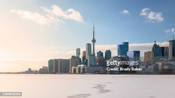 toronto city skyline on sunny winter afternoon with frozen lake - toronto stockfoto's en -beelden