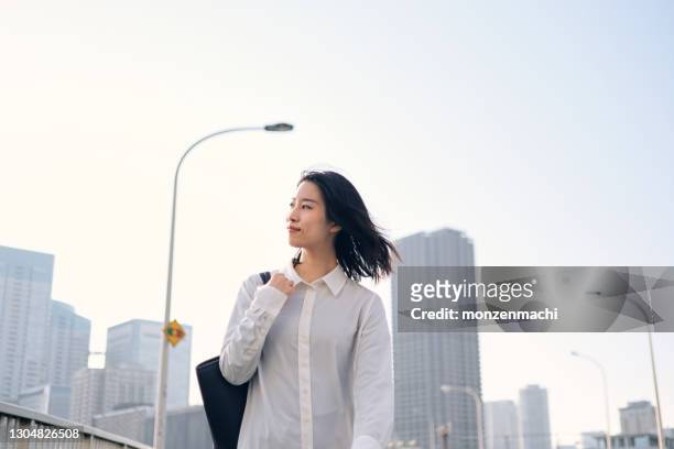 businesswoman walking on the street of modern city - japanese woman stock pictures, royalty-free photos & images