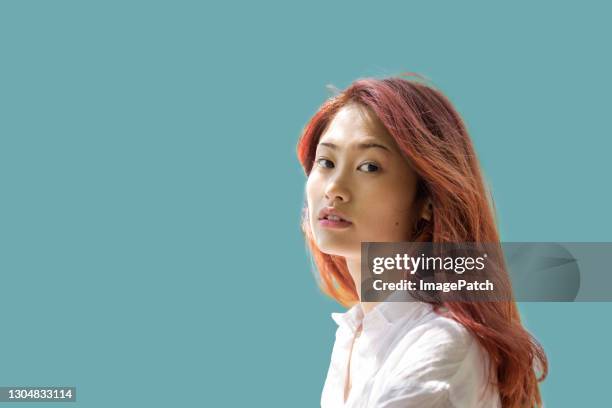 young women looking at viewer on plain coloured background - woman plain background stock pictures, royalty-free photos & images