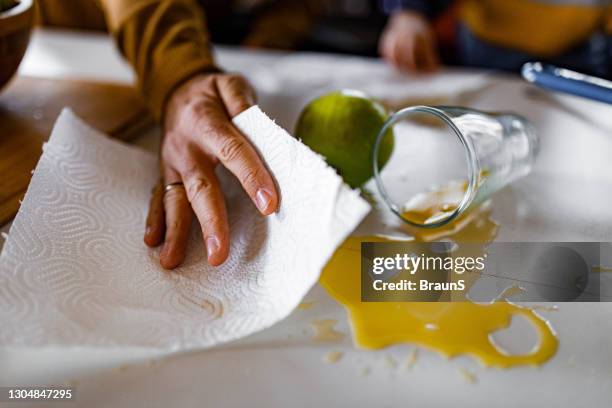 cleaning spilled orange juice! - spilled drink stock pictures, royalty-free photos & images