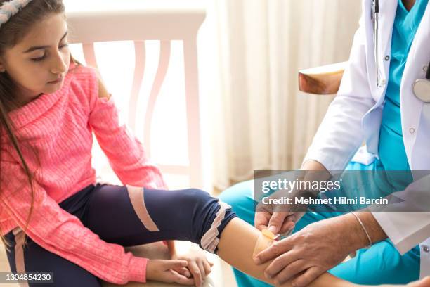 hand putting a plaster on wounded leg to doctor - bandaged thumb stock pictures, royalty-free photos & images