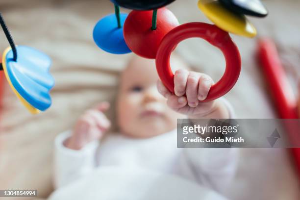 baby playing with hanging mobile. - attrezzatura per neonato foto e immagini stock