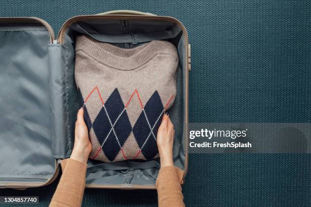 a woman packing her clothes in a suitcase (copy space) - inserir imagens e fotografias de stock